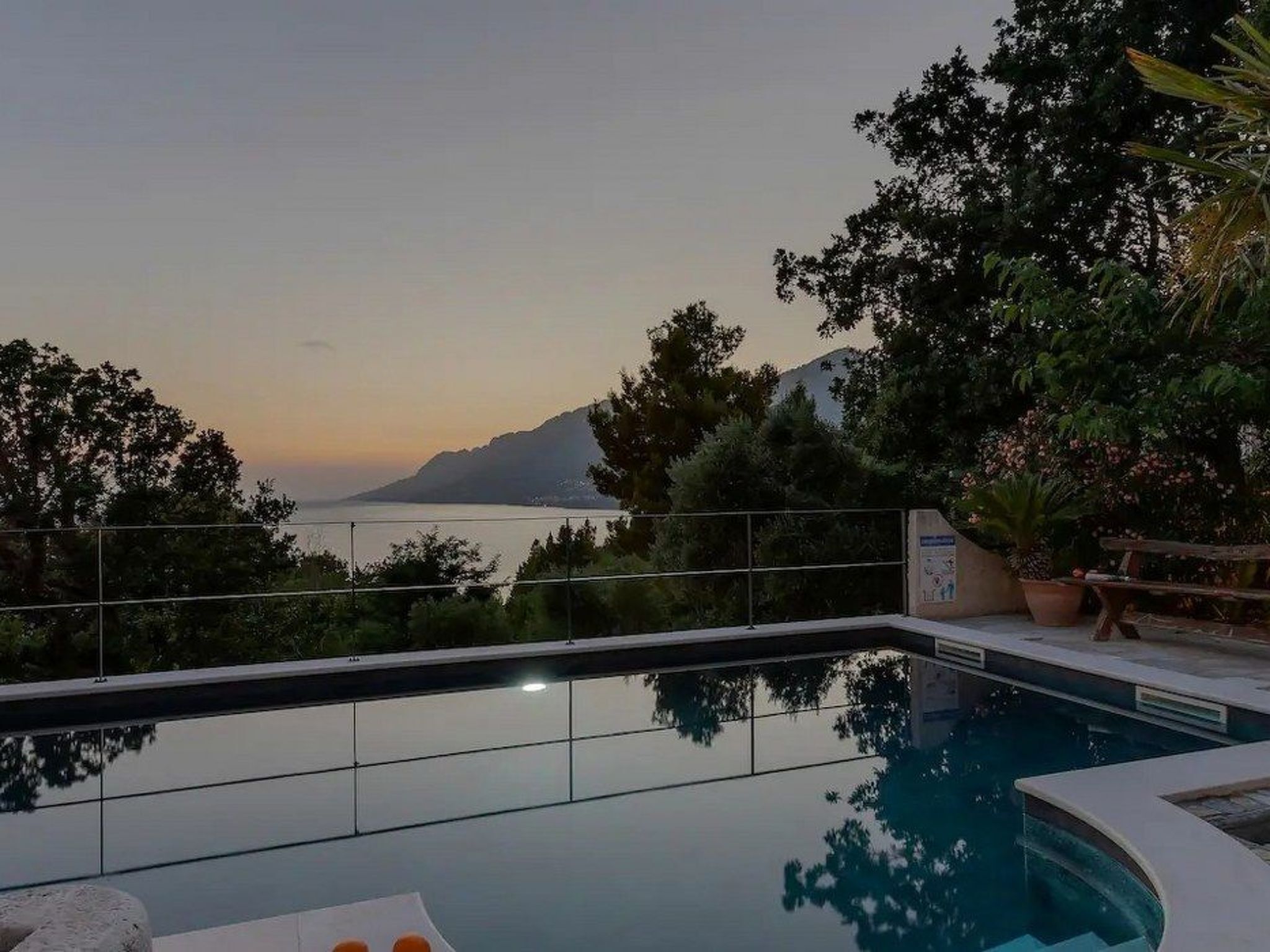 A swimming pool with a view of the sea and mountains.