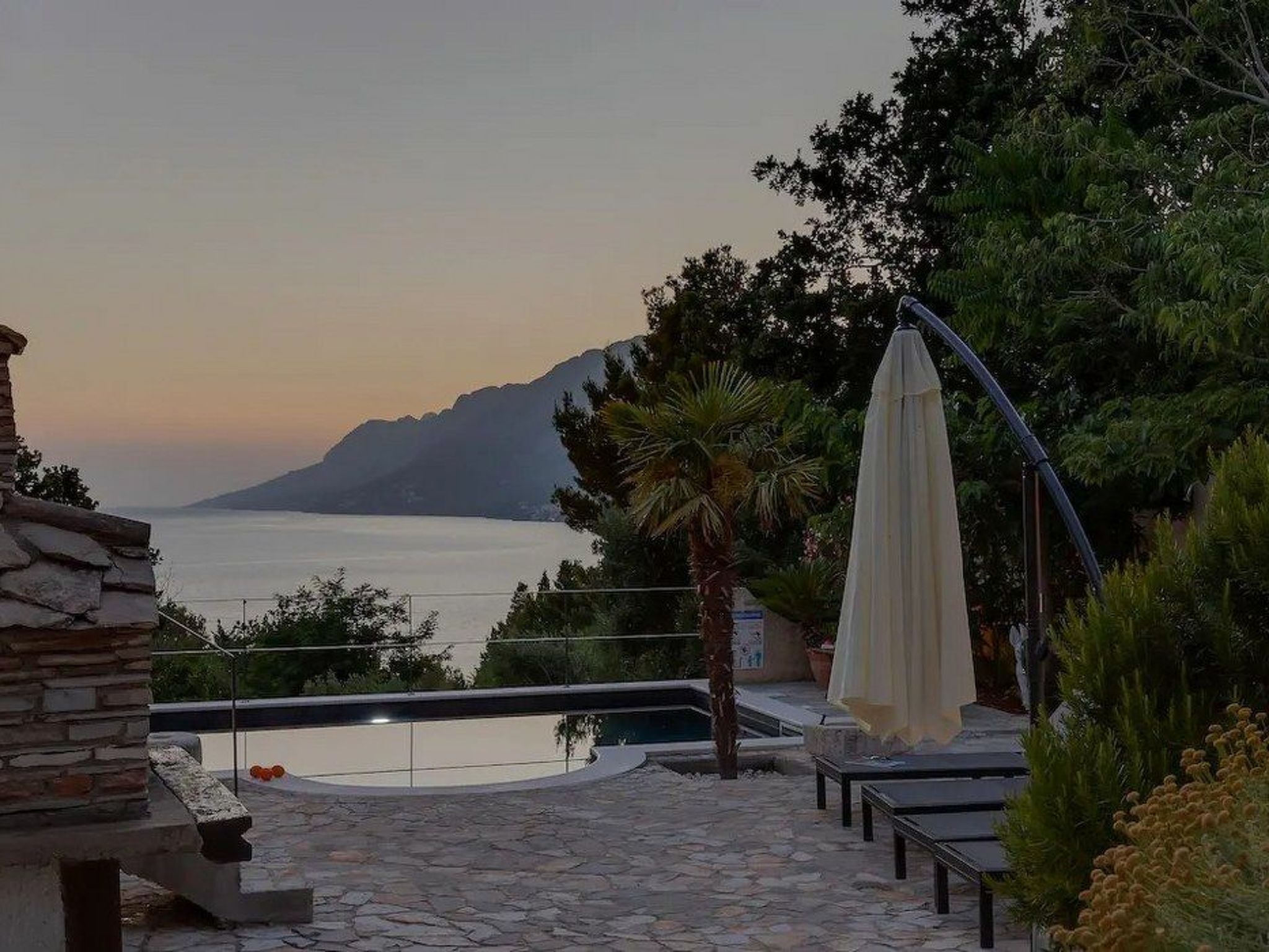 A stone pool with a view of the sea and mountains.
