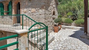 A stone building with green shutters, a stone staircase, and potted plants. - Villa Relax Brela by Interhome (Brela)