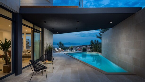 Un espace piscine extérieur moderne offrant une vue dégagée sur le ciel et le paysage environnant.