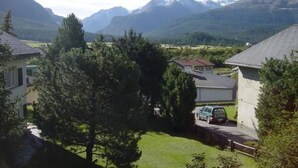 A residential area with houses, a car, and mountains in the background. - Suot Rövens by Interhome (Samedan)