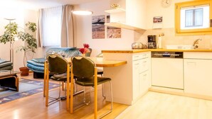 A compact living space with a dining area, kitchenette, and a sofa. - Chesa La Capriola by Interhome (Sils Maria)