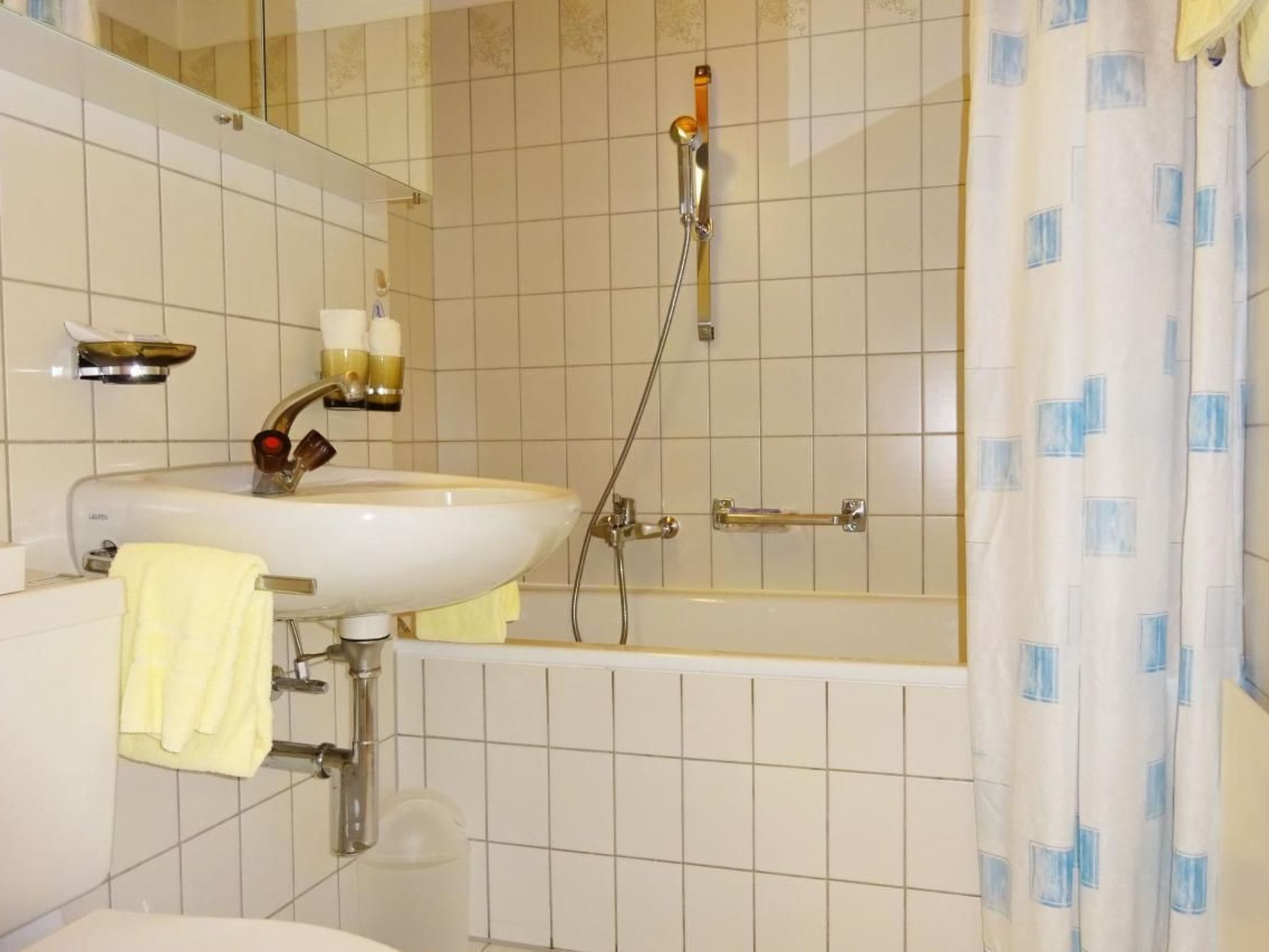 Kylpyhuone, jossa on pesuallas, peili ja suihku.