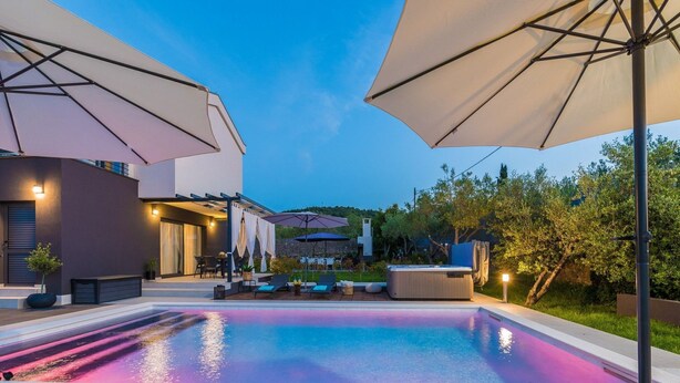 A modern outdoor pool area with lounge chairs, umbrellas, and a hot tub. - Villa Rossa by Interhome (Ugljan/Kukljica)