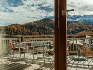 Ein Balkon mit Blick auf ein bewaldetes Gebirge.