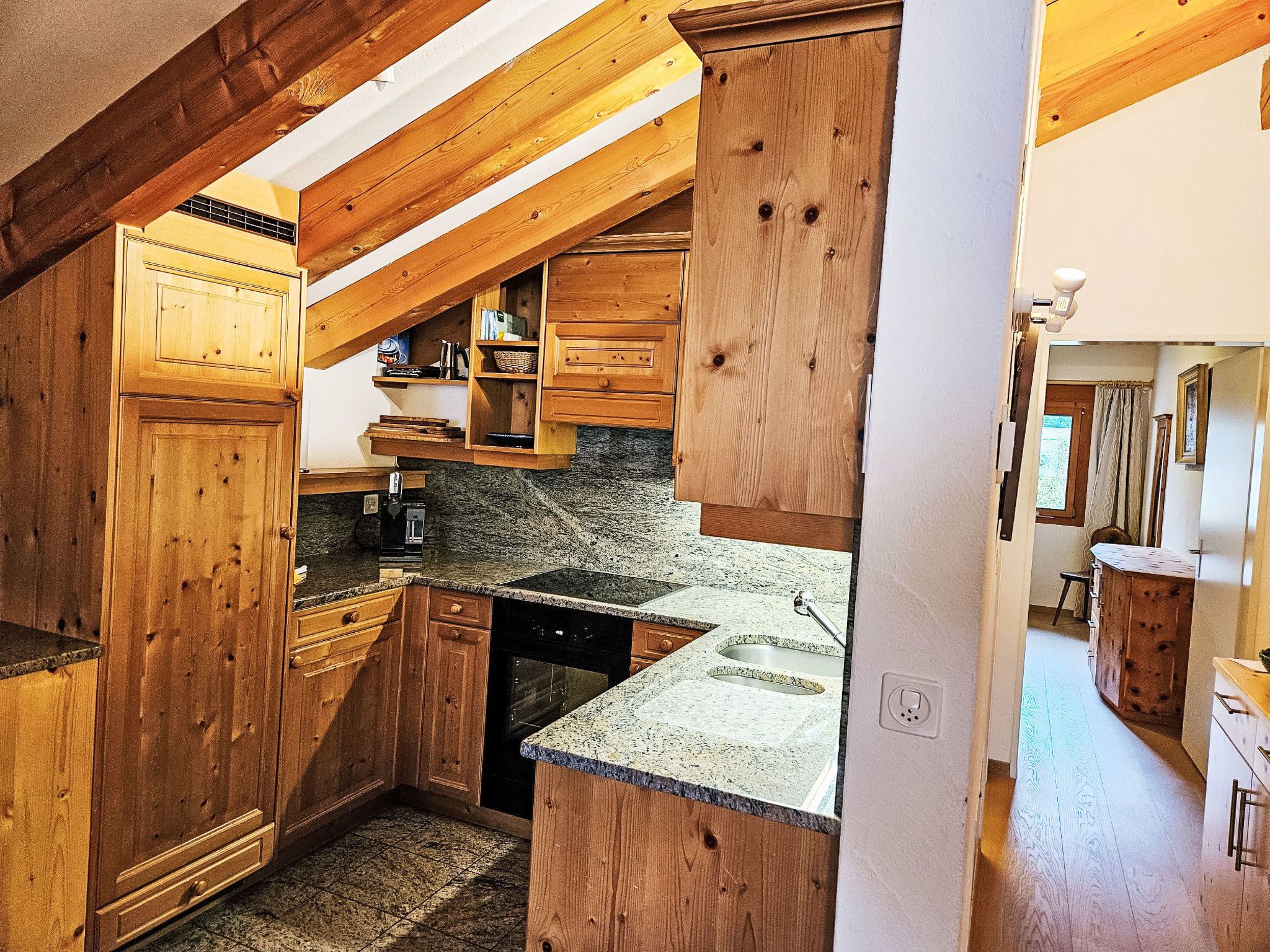 A kitchen with wooden cabinets, granite countertops, and a built-in oven.