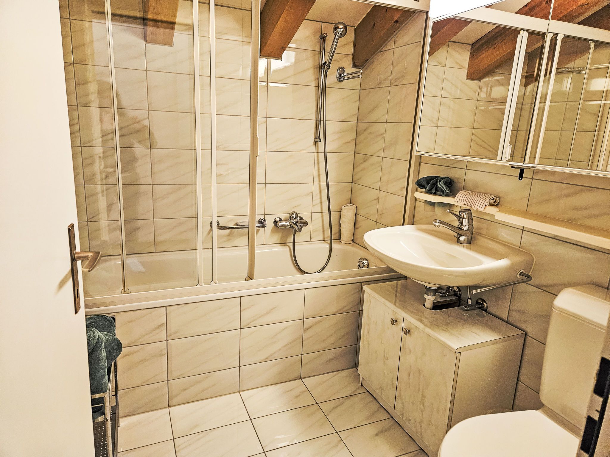Une salle de bain avec une douche, un lavabo et des toilettes.