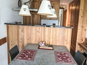 Ett kök med träskåp, en bänkskiva och två hänglampor med hjärtformade detaljer.