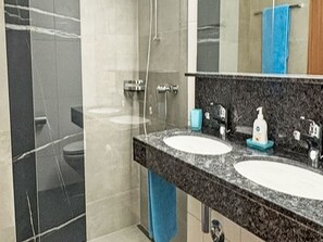 Ein Badezimmer mit zwei Waschbecken, einem Spiegel und einer Dusche.