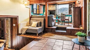 Una sala de estar acogedora con chimenea, un comedor con vistas y una cocina con alacenas de madera.