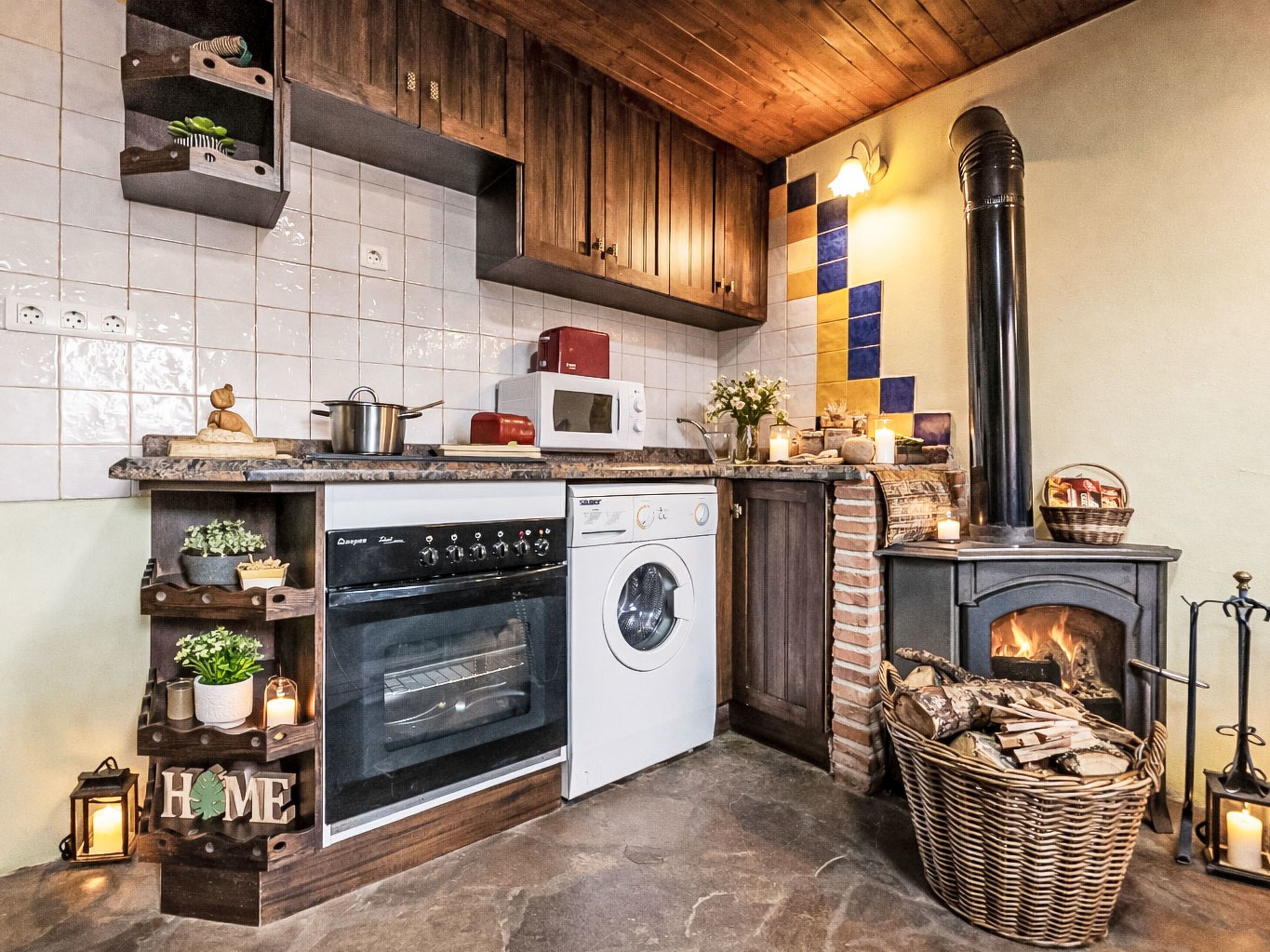 Een keuken met een fornuis, oven, magnetron en wasmachine.