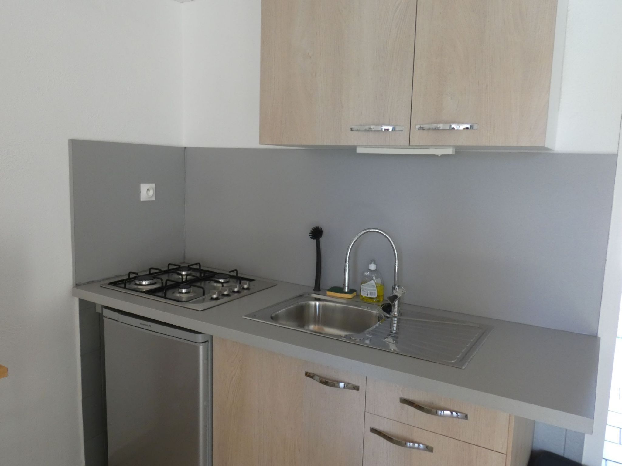 Een koelkast, een microgolfoven, kookgerei, borden en bestek