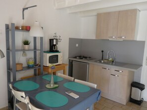 Een koelkast, een microgolfoven, kookgerei, borden en bestek