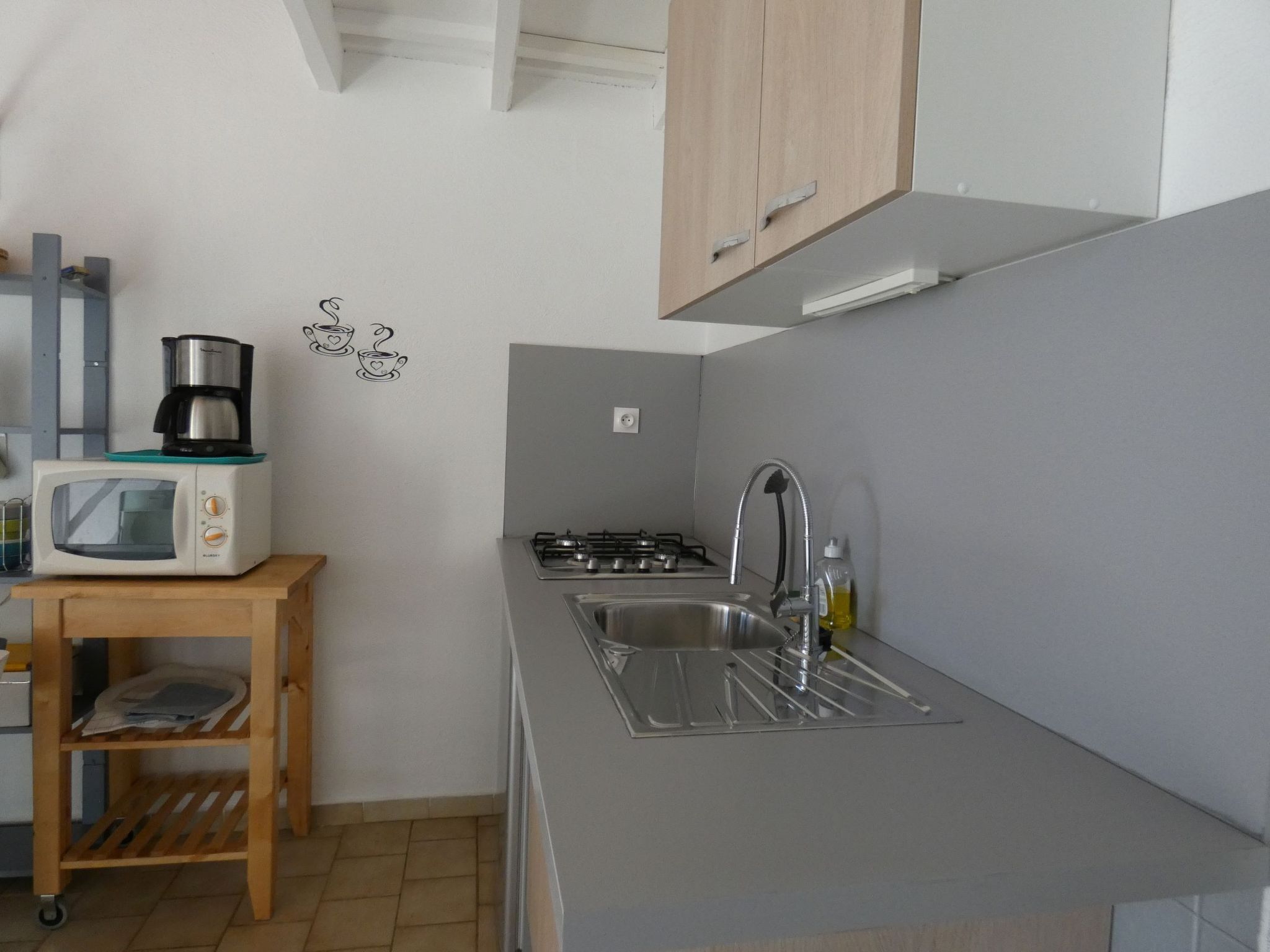 Een koelkast, een microgolfoven, kookgerei, borden en bestek