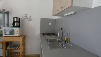 Een koelkast, een microgolfoven, kookgerei, borden en bestek