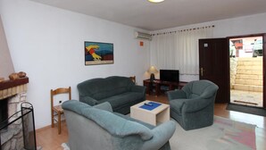 A living room with two grey sofas, a small table, a TV, and a fireplace. - Nette Ferienwohnung in Rovinj mit Offenem Kamin by Interhome (Rovinj)