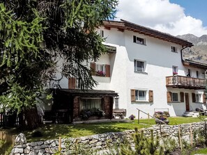 A two-story building with a stone facade, wooden shutters, and a balcony with a wooden railing. - 3 Bettwohnung by Interhome (Sils Maria)