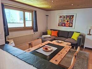 Ein gemütliches Wohnzimmer mit Sofa, Couchtisch und Esstisch.