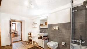 A modern bathroom with a shower, toilet, and sink. - Chesa Treig by Interhome (Samedan)
