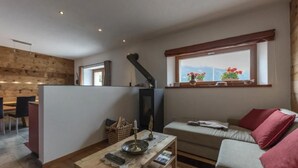 A cozy living area with a sofa, a coffee table, and a dining area with chairs. - Monte Campell Dasura by Interhome (Poschiavo)