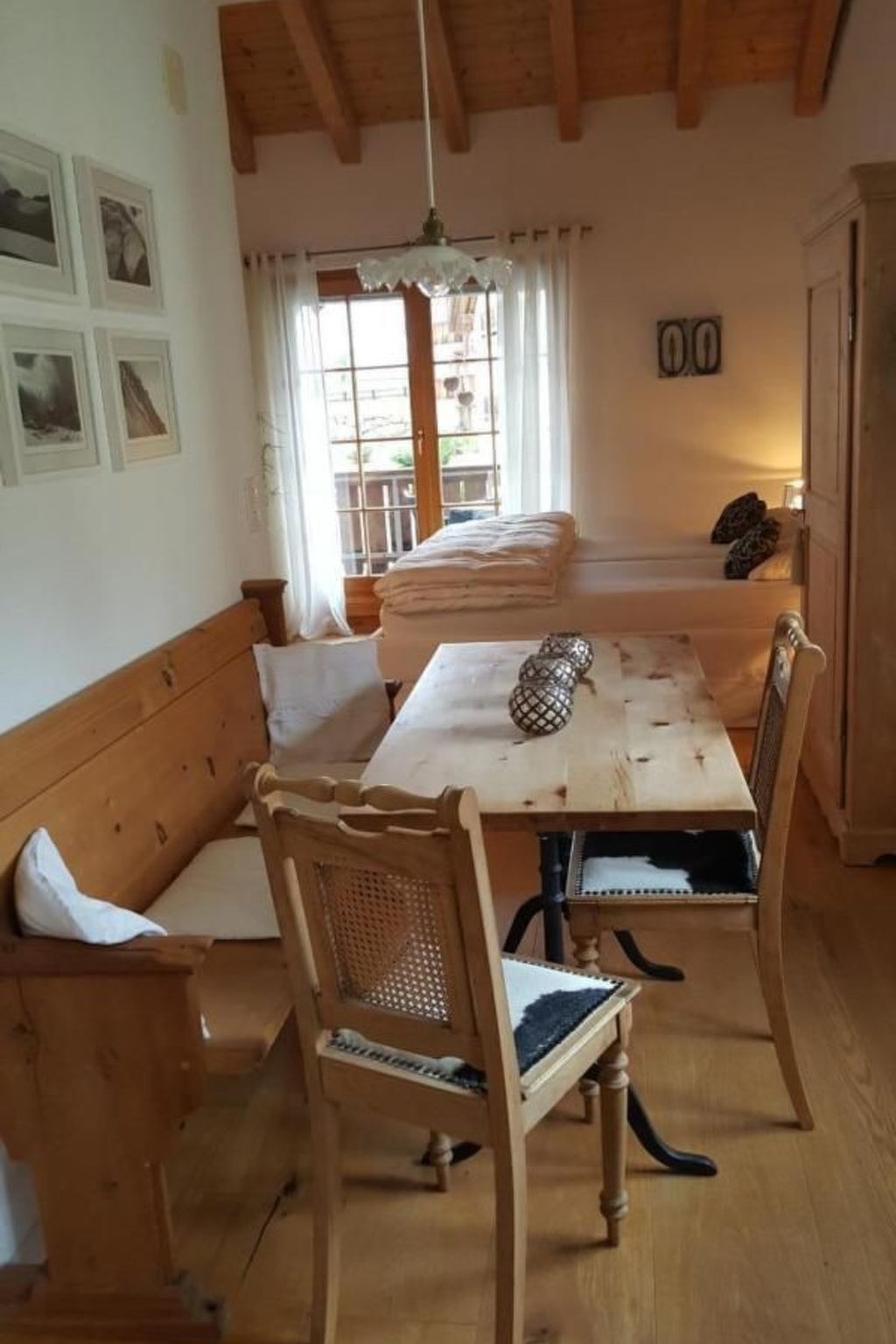 Un tavolo da pranzo in legno con sedie, una panca e un lampadario.