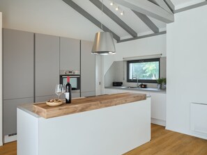 A modern kitchen with a central island, built-in appliances, and a window providing natural light. - Villa Gala by Interhome (Jakovici)