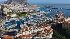 A marina with numerous boats docked, a large cruise ship, and a mountainous backdrop. - B&B Central Station  (Palermo)