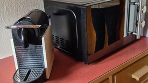Une machine à café et un four à micro-ondes sont posés sur un plan de travail.