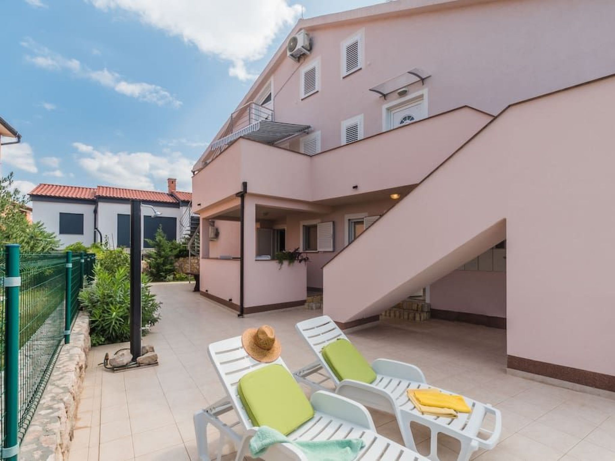 Un immeuble de deux étages doté d’un balcon et d’un escalier menant à l’étage supérieur.