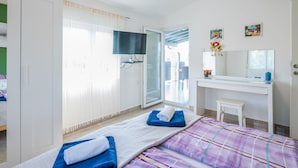 A modern hotel room with a bed, a TV, a bathroom, and a balcony. - Haus Dragica by Interhome (Krk/Čižići)