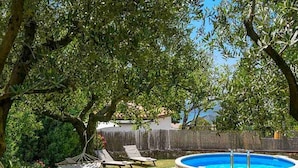 A backyard with a swimming pool, lounge chairs, and a hammock. - Komfortable, ruhige Erdgeschoss-Ferienwohnung by Interhome (Barban)