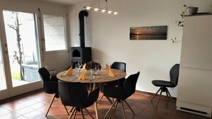 Un comedor con una mesa redonda, sillas negras y una estufa negra.