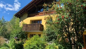 Un bâtiment à deux étages, doté d’un balcon en bois et d’une façade jaune.