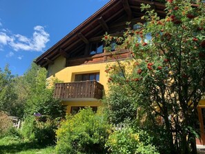 Ein zweistöckiges Gebäude mit einem hölzernen Balkon und einer gelben Fassade.
