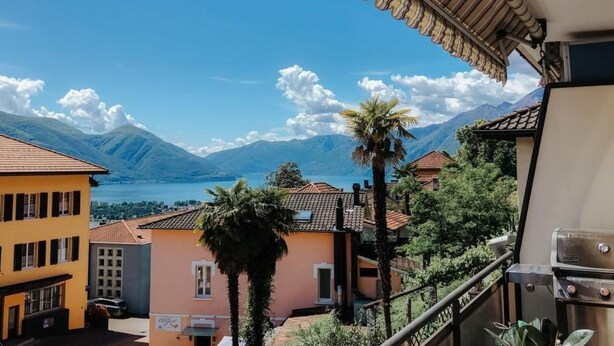 A balcony with a view of mountains and a lake. - What a view by Interhome (Orselina)
