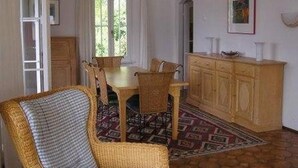 A dining area with a wooden table and chairs, a cabinet, and a patterned rug. - Villa Cresta Bianca by Interhome (Ronco sopra Ascona)