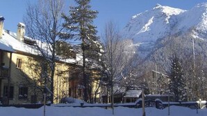 Un monte nevado con un edificio en primer plano.