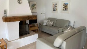 Una sala de estar con chimenea, sofá y televisión.