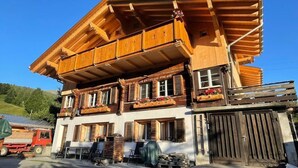 A wooden chalet with a balcony, a dining area, and a garage. - Chalet am Bühl by Interhome (Grindelwald)