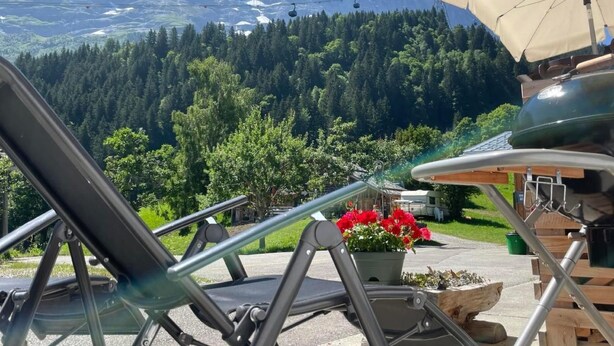 A mountain view with a chair and table setup, a grill, and a potted plant. - Chalet am Bühl by Interhome (Grindelwald)