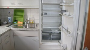 Ett kök med ett inbyggt kylskåp, en diskho och ett diskställ.