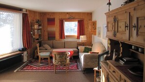 Una sala acogedora con un sofá, sillas, una mesa y un aparador.