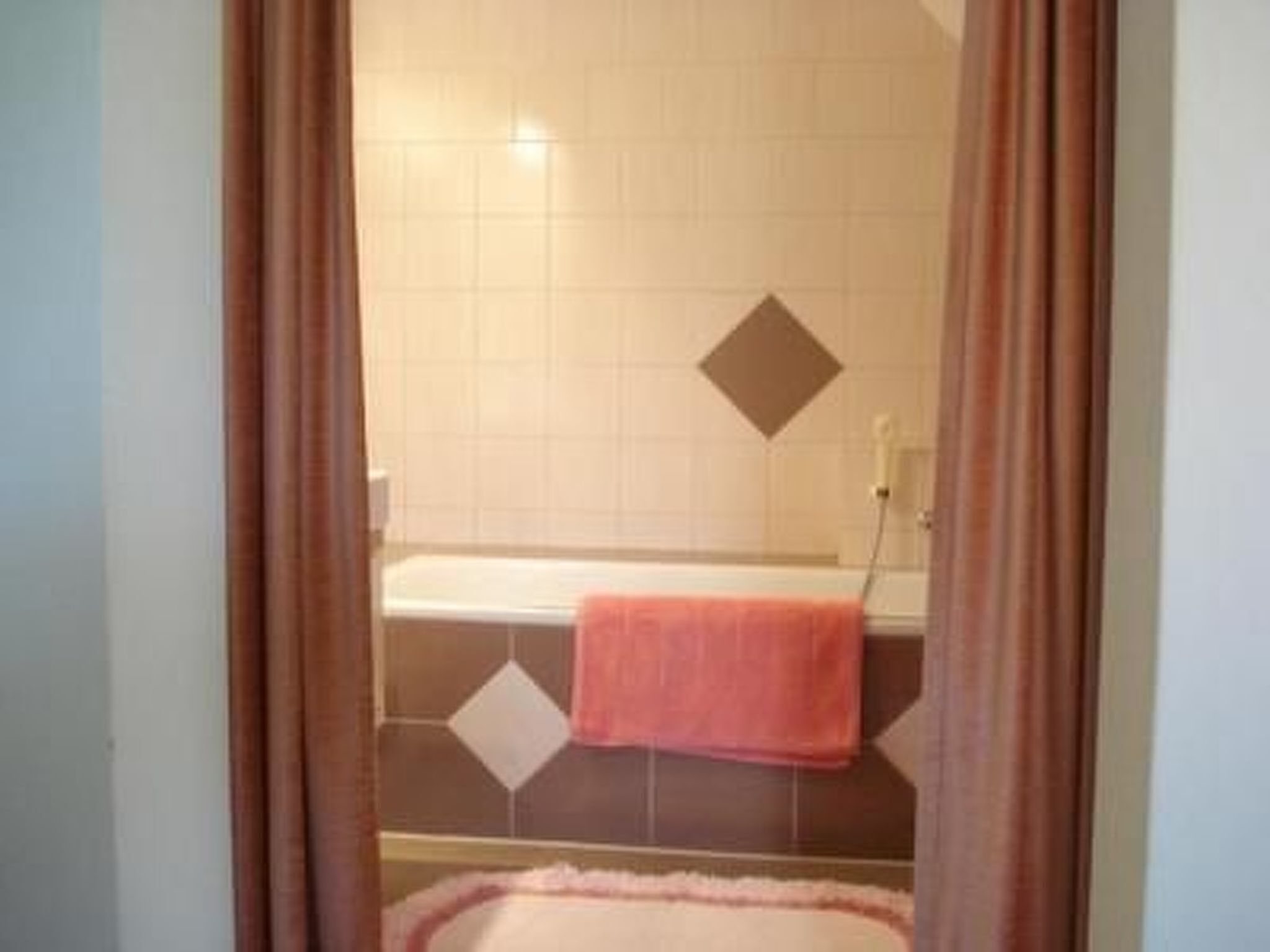 Ein Badezimmer mit Badewanne, Handtuch und Duschvorhang.