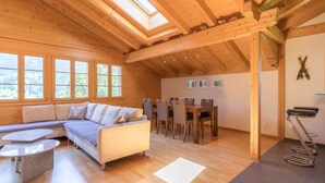 Un intérieur chaleureux, avec des éléments en bois, comprenant un canapé, une table à manger et des chaises.