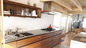 A modern kitchen with a wooden countertop, stainless steel sink, and a gas stove. - Blue Merle by Interhome (Vercorin)