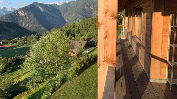 A wooden cabin with a balcony overlooking a mountainous landscape. - Blue Merle by Interhome (Vercorin)
