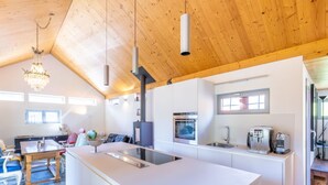 Una cocina moderna con una isla central, horno empotrado y cafeteras.