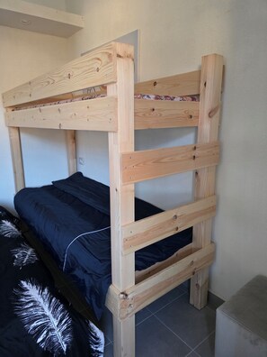 Ein Stockbett mit Holzrahmen und einer schwarzen Matratze.