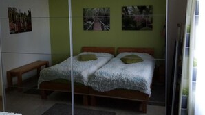 A bedroom with a bed, two pillows, a bench, and three framed pictures on the wall. - Al Bosco 71A by Interhome (Lugano)