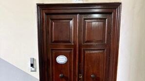 Una puerta doble de madera con un letrero que dice "Minichino House B&B".